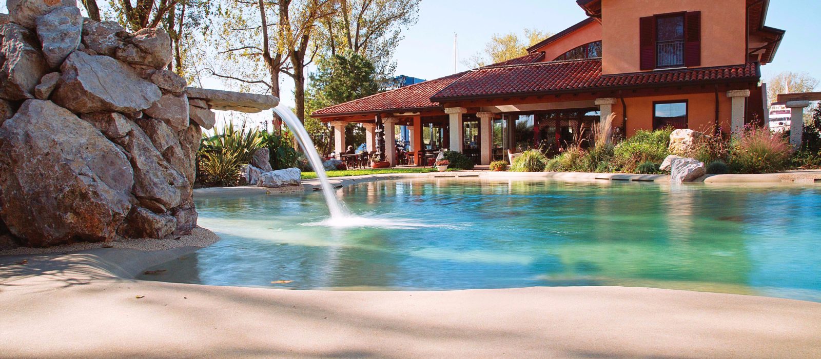 Schwimmbad mit Strand und Wasserfall